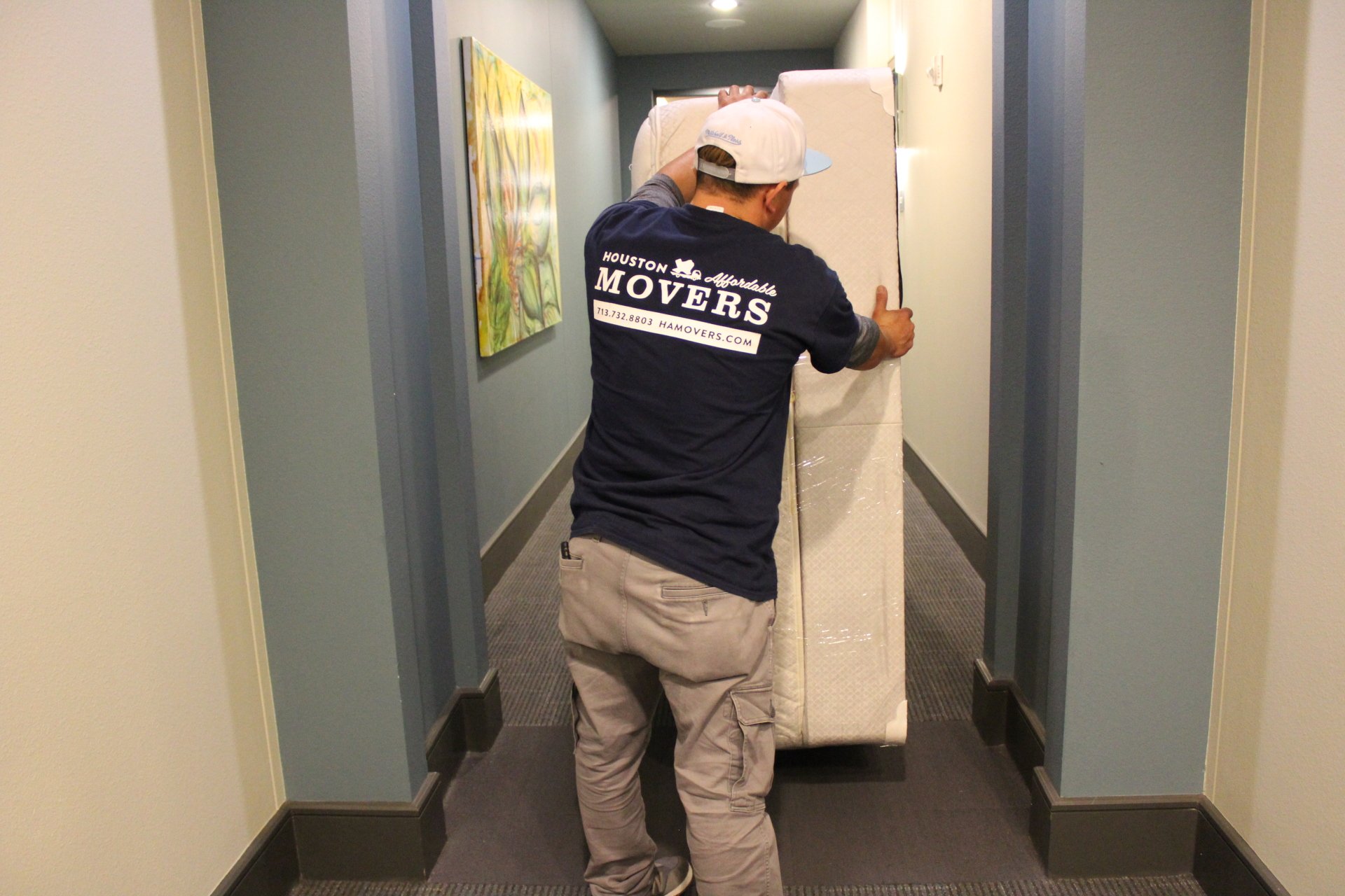 Movers Pushing Mattress Down A Hall