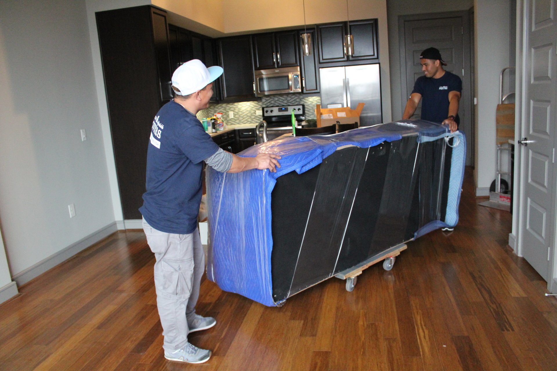 Movers Moving Sofa On Dolly